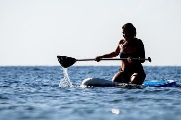 a person rowing a paddleboard in the water